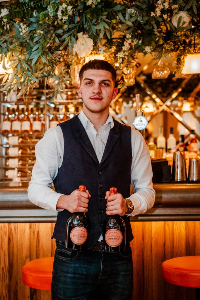 Waiter is holding two bottles of champagne at Piccolino