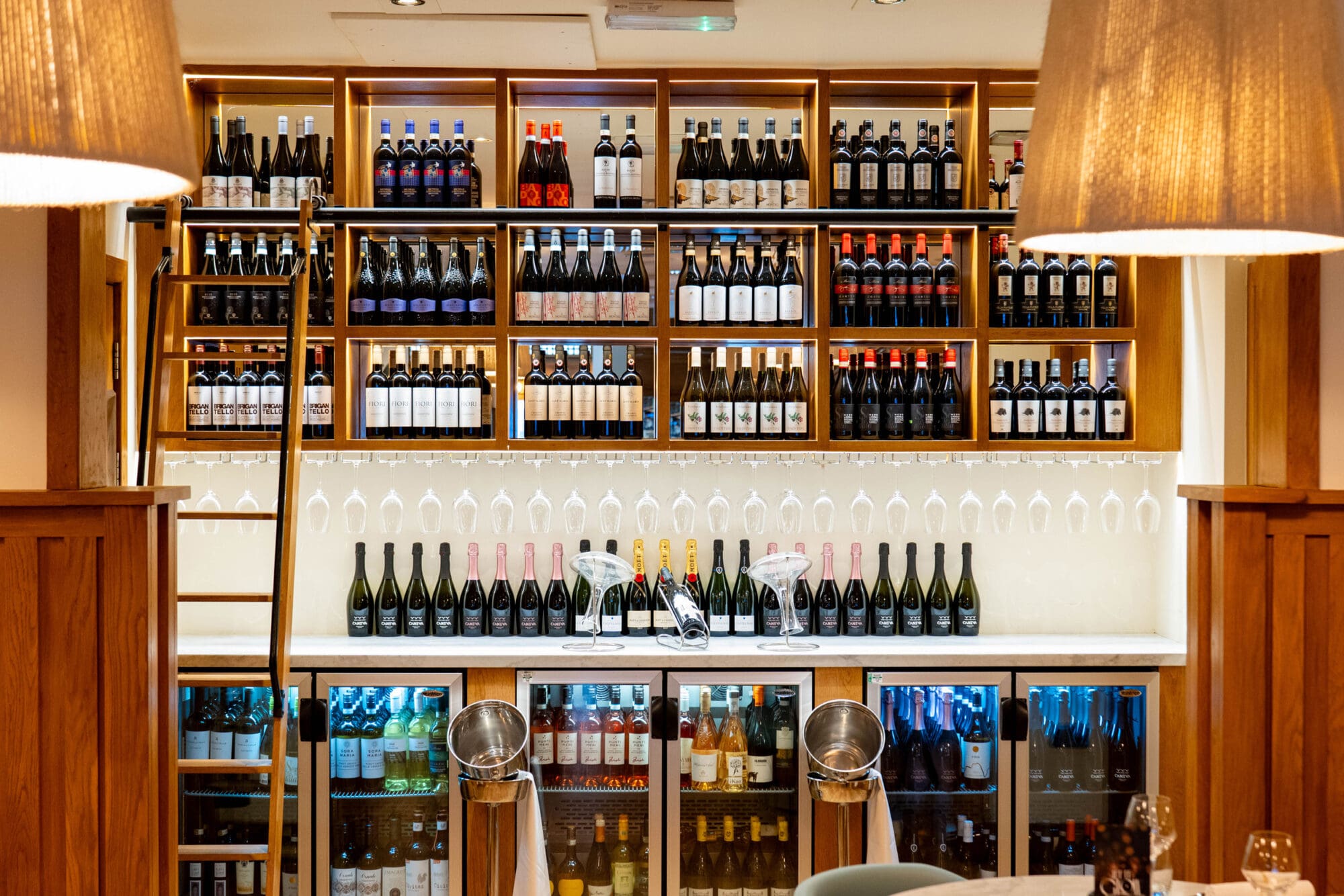 Fully stocked wine cabinet with glasses.
